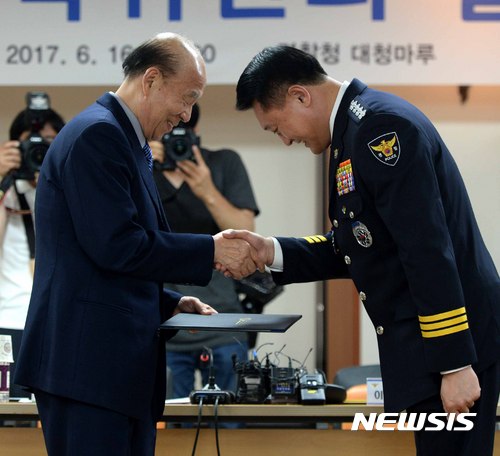【서울=뉴시스】고범준 기자 = 이철성 경찰청장(오른쪽)이 16일 오후 서울 서대문구 경찰청 대청마루에서 열린 경찰개혁위원회 발족식에서 박경서 경찰개혁위원장에게 위촉장을 수여하고 악수를 하고 있다. 2017.06.16. bjko@newsis.com