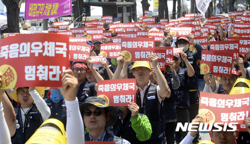 【서울=뉴시스】최진석 기자 = 18일 오후 서울 세종로 소공원에서 전국집배노동조합 주최로 진행된 '전국우정노동자 총력 결의대회'에 참가한 조합원들이 피켓을 들고 구호를 외치고 있다. 2017.06.18. myjs@newsis.com