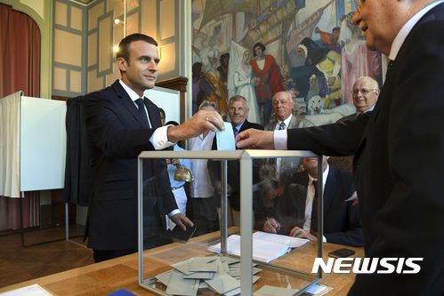 【르투케=AP/뉴시스】에마뉘엘 마크롱 프랑스 대통령이 18일(현지시간) 르투케에서 총선 결선투표를 하고 있다 2017.06.18
