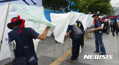 【서울=뉴시스】전진환 기자 = 건설노조 1만 토목건축 조합원 상경총회가 열린 20일 오후 서울 광화문 세종로공원에서 조합원들이 2017년 토목건축분과위원회 총파업 찬반투표를 하고 있다. 2017.06.20. amin2@newsis.com