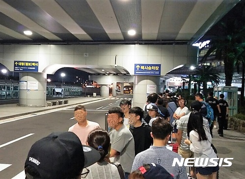 제주공항 택시 승차장에서 50m 긴줄을 만들고 택시 오기를 기다리는 도민과 관광객들.