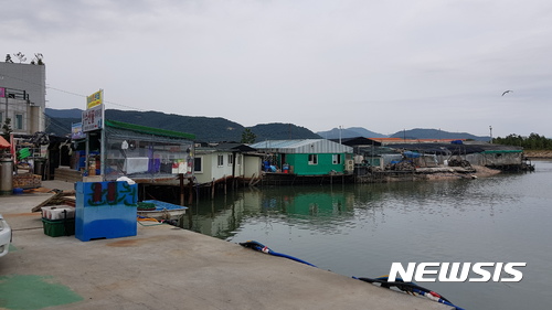 【창원=뉴시스】 홍정명 기자 = 26일 경남 창원시 진해구 용원동 의창수협 주차장에서 바라본 ‘용원수산물재래시장’ 전경. 모두 불법 가설물이며, 오른쪽 끝은 공유수면 지역으로 굴껍질 등을 버리면서 무단 매립된 곳이다.2017.06.26. hjm@newsis.com