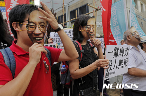 【홍콩=AP/뉴시스】 주홍콩 중국연락판공실 건물 앞에서 27일 인권운동가들이 간암 말기 판정을 받고 가석방된 인권운동가 류샤오보의 얼굴 가면을 쓰고 시위를 벌이고 있다. 이들은 중국 정부에 류샤오보의 무조건 석방을 촉구했다.  2017.06.27