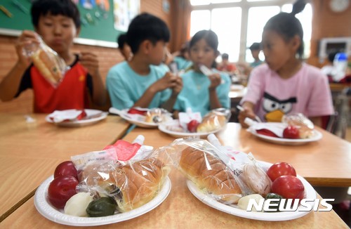 【수원=뉴시스】권현구 기자 = 전국학교비정규직노동조합이 총파업에 돌입한 29일 오전 경기도 수원시 팔달구 매향동의 한 초등학교에서 학생들이 급식 대신 지급된 빵을 먹고 있다. 조리종사원·영양사·행정실무 등 학교의 비정규직 직원들이 임단협 결렬에 따라 시·도 교육청은 급식실의 정상적인 운영이 어려울 경우 단축수업 혹은 도시락 지참이나 빵·우유 등으로 대체할 것을 일선 학교에 지시했다. 2017.06.29. photo@newsis.com