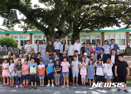 【제주=뉴시스】조수진 기자 = 제주시 구좌읍 종달초등학교 학생, 학부모, 교사, 제주교육청 관계자들이 6일 오전 학교 운동장 앞 폭낭 정원에서 기념 촬영을 하고 있다. 2017.07.06. susie@newsis.com