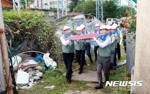 【창원=뉴시스】 홍정명 기자 = 6일 경남 창원시 진해구 용원동에서 경남농협 이구환(왼쪽 첫 번째)  경남본부장, 김성찬(오른쪽 첫 번째) 국회의원 등이 사랑의 집 고치기에 사용될 건축 자재를 운반하고 있다.2017.07.06.(사진=경남농협 제공) photo@newsis.com