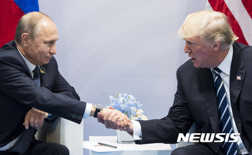 【함부르크=AP/뉴시스】7일(현지시간) 독일 함부르크에서 개막한 주요20개국(G20) 정상회의를 계기로 만난 도널드 트럼프 미국 대통령(오른쪽)과 블라디미르 푸틴 러시아 대통령이 악수를 하고 있다. 2017.07.08 