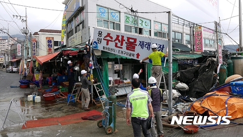 【창원=뉴시스】 홍정명 기자 = 10일 오전 경남 창원시 진해구청에서 동원한 철거업체 직원들이 도로 위에 불법으로 형성된 용원동 용원수산물재래시장의 불법구조물(지붕)과 입구 시장 간판을 철거하고 있다.2017.07.10. hjm@newsis.com