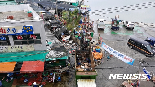 【창원=뉴시스】 홍정명 기자 = 10일 오전 경남 창원시 진해구청에서 동원한 철거업체 직원들이 도로 위에 불법으로 형성된 용원동 용원수산물재래시장의 불법구조물(지붕)과 간판 등 시설물을 철거하고 있다.2017.07.10. hjm@newsis.com