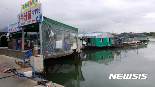 【창원=뉴시스】 홍정명 기자 = 10일 오전 경남 창원시 진해구청에서 동원한 철거업체 직원들이 도로 위에 불법으로 형성된 용원동 용원수산물재래시장의 불법구조물(지붕) 철거에 나선 가운데 시장 내 도로와 연결된 옛 선착장과 공유수면 위에 무단으로 설치된 불법가설물들. 이곳은 진해구청이 아닌 부산지방해양수산청 관할이어서 이번 구청 철거 대상에서는 제외됐다.2017.07.10. hjm@newsis.com 