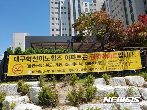 【대구=뉴시스】이통원 기자 = 대구지역 지자체들이 최근 15곳의 금연아파트를 지정한 가운데 금연아파트제도에 필요한 단속계획이 없고 인력 등도 부족해 전시적인 행정에 그칠수 있다는 우려의 목소리가 나오고 있다. 사진은 대구 동구 혁신이노힐즈 아파트 울타리에 금연 아파트를 알리는 현수막이 걸려있는 모습이다. 2017.07.13. (사진=대구 동구청 제공)<a href="mailto:photo@newsis.com">photo@newsis.com</a>