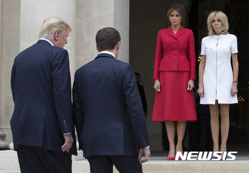 【파리=AP/뉴시스】도널드 트럼프 미국 대통령(왼쪽)과 에마뉘엘 마크롱 프랑스 대통령이 13일(현지시간) 파리 앵발리드(군사박물관)에서 대화를 나누고 있다. 맞은편에는 트럼프의 부인 멜라니아(왼쪽 붉은 의상)와 마크롱의 아내 브리짓이 서 있다. 2017.7.14.