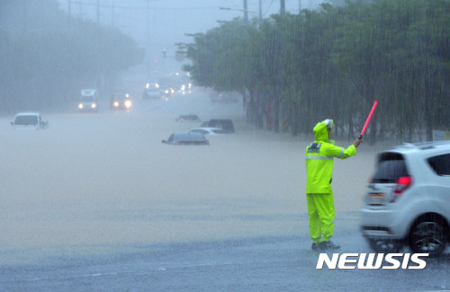 【청주=뉴시스】이병찬 기자 = 16일 내린 집중호우로 충북 청주시 산남동 교차로와 주차 차량들이 침수돼 경찰관들이 차량 통행을 통제하고 있다. 호우 경보가 내린 청주 지역에는 이날 200㎜ 이상의 물폭탄이 쏟아졌다.2017.07.16.&nbsp; bclee<a href="mailto:bclee@newsis.com">@newsis.com</a> 