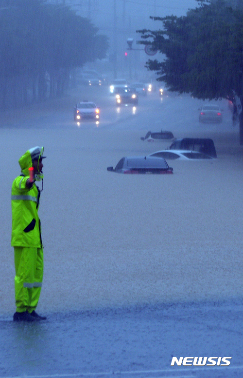 【청주=뉴시스】이병찬 기자 = 16일 내린 집중호우로 충북 청주시 산남동 교차로와 주차 차량들이 침수돼 경찰관들이 차량 통행을 통제하고 있다. 호우 경보가 내린 청주 지역에는 이날 200㎜ 이상의 물폭탄이 쏟아졌다.2017.07.16.&nbsp; bclee@newsis.com