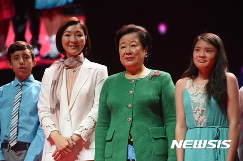 【서울=뉴시스】 15일(현지시간) 미국 뉴욕 '매디슨 스퀘어 가든'에서 열린 특별 평화집회에서 세계평화통일가정연합 한학자 총재(오른쪽에서 두 번째)와 문선진 세계회장(오른쪽에서 세 번째)이 현지 어린이들과 포즈를 취했다. (사진=가정연합 제공)