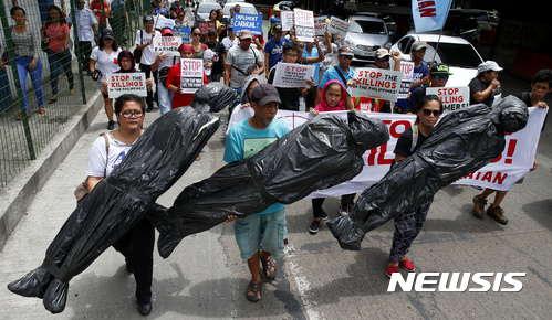 【케손시티(필리핀)=AP/뉴시스】필리핀 시위대가 20일 마닐라 북동부 케손시티의 경찰서 앞에서 로드리고 두테르테 대통령의 마약과의 전쟁 과정에서 숨진 수천명의 희생자를 상징하는 허수아비들을 들고 행진하고 있다. 미 의회 인권위원회는 두테르테 대통령의 마약과의 전쟁에 대해 조사할 계획이라고 밝혔다. 2017.7.20