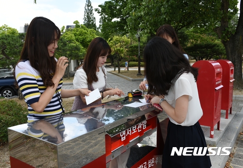 【경주=뉴시스】강진구 기자 = 경상북도관광공사(사장 김대유)는 보문관광단지 느린우체통 이용객이 1만6000명을 돌파했다고 24일 밝혔다.사진은 지난 주말 보문단지를 찾은 관광객들이 느린우편엽서를 쓰고 있다.2017.07.24.(사진=경상북도관광공사 제공)  photo@newsis.com