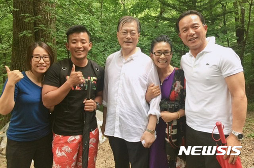 【서울=뉴시스】 지난해 7월 첫 여름 휴가를 맞아 등산 도중 시민들과 기념사진을 찍었던 문재인 대통령의 모습.(사진=뉴시스DB) 2017.07.31. 