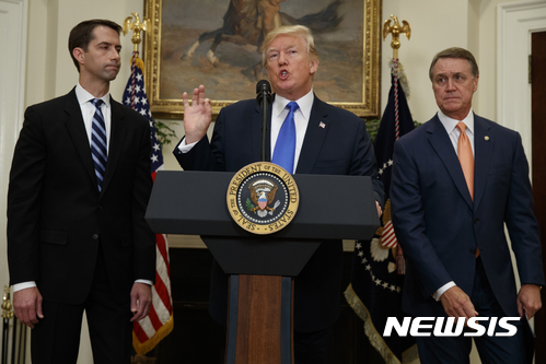 【워싱턴=AP/뉴시스】 워싱턴포스트(WP)는 7일(현지시간) 트럼프 대통령의 공약 실천 가능성에 회의를 품은 미국 기업들이 고용과 투자를 주저하면서 확장 기미를 보이던 미국의 경제를 주눅 들게 하고 있다고 보도했다. 트럼프 대통령(가운데)이 2일(현지시간) 백악관에서 공화당의 톰 코튼(아칸소)(왼쪽), 데이비드 퍼듀(조지아) 상원의원과 새롭게 추진할 이민 정책에 관해 설명하고 있다. 2017.8.8.