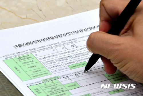 【서울=뉴시스】박진희 기자 = 정부가 서울 전역을 투기과열지구로 묶고, 대출 규제를 강화한 8·2 부동산대책 시행을 앞둔 3일 오후 서울 영등포구 한 은행 창구에서 한 고객이 대출서류를 작성하고 있다. 정부는 지난 2일 서울시 전역과 경기 과천, 세종시 등 투기과열지구의 주택담보인정비율(LTV)과 총부채상환비율(DTI)의 한도를 40%로 강화하고, 이중 강남 4구 등 투기지구로 묶인 11곳에 대해서는 주택담보대출을 가구당 1건으로 제한키로 했다. 강력한 대출 규제책에 놀란 대출 수요자들은 대출 시기를 앞당겨야 하는지, 대출 한도는 얼마나 줄어드는지를 걱정하며 상황을 예의주시하는 모습을 보이고 있다. 2017.08.03. pak7130@newsis.com