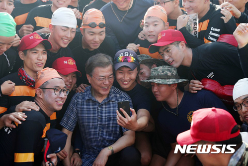 【서울=뉴시스】 전신 기자 = 지난 3일 진해 공관에서 휴가중인 문재인 대통령이 거북선 모형함을 방문하기 위해 이동중 인근에서 전투 수영 훈련을 하는 해군사관학교 생도들 만나 격려한 뒤 기념촬영 하고 있다. 2017.08.04. (사진=청와대 제공)&nbsp; photo@newsis.com 