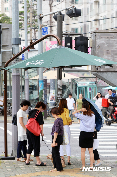 【서울=뉴시스】 강한 햇빛에 시민들이 그늘막에 들어와 있다. (사진=뉴시스 DB)