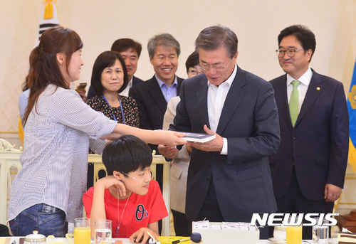 【서울=뉴시스】전진환 기자 = 문재인 대통령이 8일 오후 청와대 인왕실에서 열린 가습기 살균제 피해자 간담회에 참석한 피해자 임성준군의 엄마 권은진씨로부터 서적 '가습기 살균제 리포트'를 선물 받고 있다. 2017.08.08.&nbsp; amin2@newsis.com