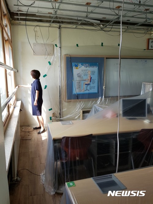 【과천=뉴시스】 장태영기자 = 석면철거 공사가 완료된 경기 과천시 소재 관문초등학교 교실에서 발암물질인 백석면이 무더기로 검출됐다. 현재 해당학교는 폐쇄된 상태다. 사진은 지난 7일 학부모들이 학교의 한 교실에서 석면시료를 체취하고 있는 모습. 2017.08.09. (사진=관문초 비대위 제공) photo@newsis.com