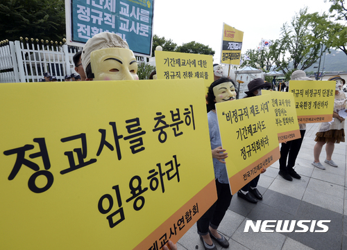 【서울=뉴시스】최진석 기자 = 9일 오후 종로구 정부서울청사 앞에서 전국기간제교사연합회 주최로 진행된 '기간제교사도 교사다! 정규직화하라! 집회'에 참석한 기간제교사들이 가면을 쓴 채 기간제교사 정규직화, 정교사 확충 촉구 피켓을 들고 있다. 2017.08.09. myjs@newsis.com