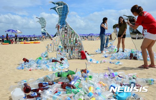【부산=뉴시스】 하경민 기자 = 13일 부산 해운대해수욕장에서 국제환경단체 '그린피스' 활동가들이 일회용 플라스틱으로 뒤덮인 해변을 표현한 미술작품을 설치하고 있다. 그린피스 서울사무소는 이날부터 사흘 동안 해운대해수욕장에서 일회용 플라스틱 사용 줄이기를 권장하는 이색 시민체험 행사를 진행한다. 2017.08.13.&nbsp; yulnetphoto@newsis.com