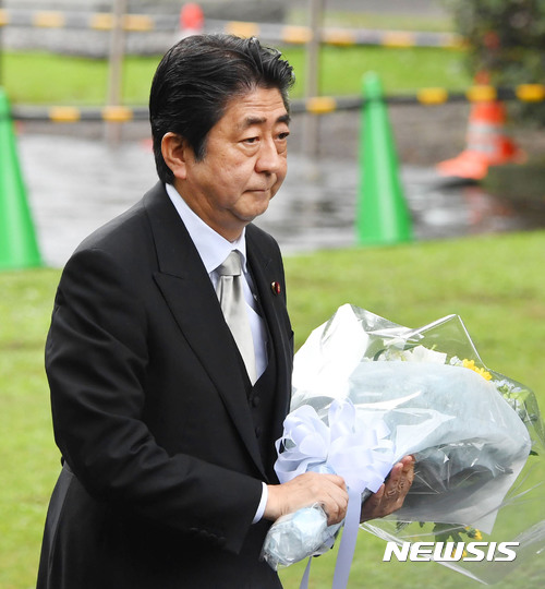 【도쿄=교도·AP/뉴시스】 아베 신조 일본 총리가 15일 일본의 종전기념일(패전일)을 맞아 도쿄 국립묘지에서 열린 2차대전 전몰자추도식에 참석해 꽃다발을 들고 걸어가고 있다.2017.08.15