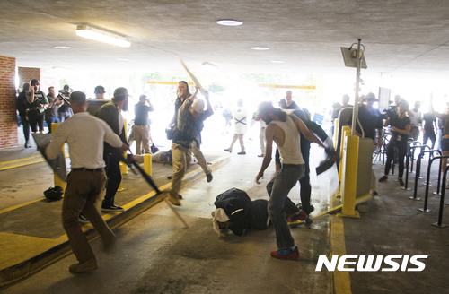 【샬러츠빌=AP/뉴시스】미국 버지니아주 샬러츠빌에서 12일(현지시간) 일군의 남성들이 주차장 바닥에 쓰러진 남성에게 몽둥이질과 발길질을 하고 있다. 이날 샬러츠빌에서는 극우 백인우월주의 시위와 이에 반대하는 시위가 충돌해 난장판이 벌어졌으며, 한 남성이 자동차를 몰고 반대 시위대 속으로 돌진해 1명이 사망하고 20여명이 부상을 입는 사건이 일어났다. 2017.08.16&nbsp; 