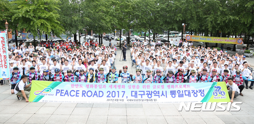 【대구=뉴시스】우종록 기자 = 16일 오전 대구 중구 동인동 국채보상운동기념공원 달구벌대종 앞에서 열린 '피스로드 코리아 2017, 대구시 통일대장정'행사에 앞서 자전거 종주 참가자들이 기념촬영을 하고 있다. 2017.08.16. wjr@newsis.com