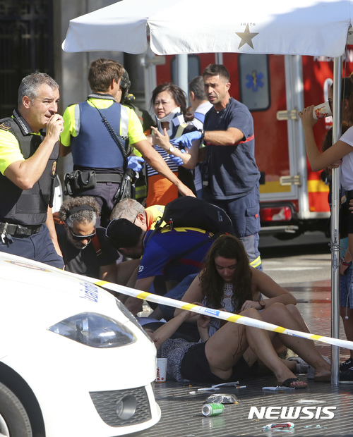 【 바르셀로나=AP/뉴시스】스페인 바르셀로나에서 17일(현지시간) 경찰과 구급요원들이 차량 돌진 테러로 다른 사람들을 돌보고 있다. 2017.08.18 