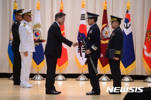 【서울=뉴시스】전신 기자 = 문재인 대통령이 20일 서울 용산구 국방부 대강당에서 열린 합참의장 이·취임식에서 정경두 신임 합참의장의 삼정도(三情刀)에 수치(綬幟)를 달아준 뒤 악수를 하고 있다. 삼정도는 '육해공 3군이 일치단결해 호국·통일·번영을 달성하라'는 의미를 담은 칼이다. 군 장성(준장) 진급시 수여되며, 수치는 끈으로 된 깃발로 진급·보직 신고를 하는 군 장성의 직위와 이름, 진급일 등이 수놓아져 있다. 2017.08.20. photo1006@newsis.com