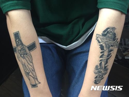 【서울=뉴시스】 지난 10일 홍대 거리의 한 타투 가게에서 리터칭 작업을 기다리고 있던 왕모(20)씨의 양팔에 새겨진 타투. 독실한 기독교 신자인 그는 예수님과 십자가 모양을 새겼다. 2017.08.27.