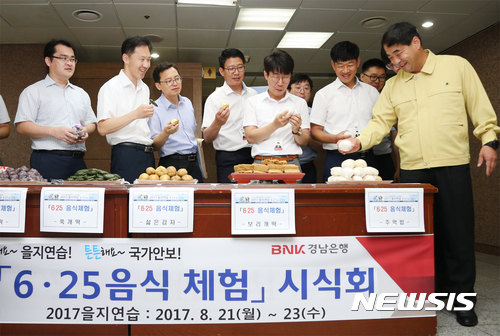 【창원=뉴시스】 홍정명 기자 = 21일 BNK경남은행 본점이 마련한 '6·25 음식 체험 시식회'에 참가한 직원들이 주먹밥, 보리개떡 등 6·25 전쟁 당시 먹었던 음식을 시식하고 있다. 시식회는 21~24일 을지연습 기간 동안 운영한다.2017.08.21.(사진=BNK경남은행 제공) photo@newsis.com