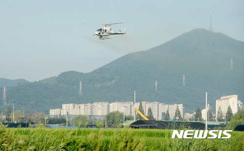 【서울=뉴시스】김진아 기자 = 지난해 8월22일 오전 서울 강서구 과해동 벼 재배 지역에서 병충해 방지를 위해 영양제 성분이 포함된 친환경 약을 이용한 항공방제 작업을 하고 있다. 2017.08.22. bluesoda@newsis.com