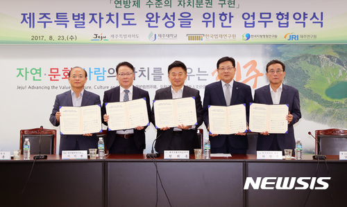 【제주=뉴시스】강정만 기자 =&nbsp; 제주특별자치도 분권모델 완성의 효율적 추진과 제주특별법 개정을 위해 제주도등 5개 기관이 23일 제주도청 삼다홀에서 업무협약을 맺었다. 사진은 강기춘 제주연구원장, 이익현 한국법제연구원장, 원희룡 제주지사, 허향진 제주대총장, 김선기 한국지방행정연구원장(왼쪽부터)이 협약서를 들어보이고 있는 모습.&nbsp; 2017.08.23 (사진= 제주도청 제공) photo@newsis.com