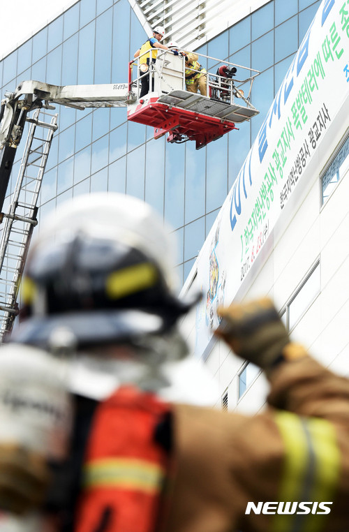 【수원=뉴시스】이정선 기자 = 2017 을지연습 실제훈련 일환으로 한국지역난방공사 광교지사 폭발 테러에 따른 종합조치훈련이 실시된 23일 오후 경기 수원 한국지역난방공사 광교지사에서 소방대원들이 옥상에 고립된 관계자를 구조하고 있다. 2017.08.23. ppljs@newsis.com