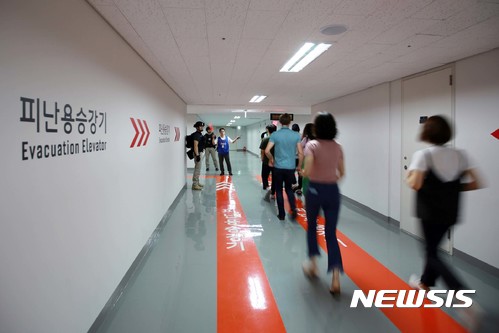 【서울=뉴시스】 23일 서울 송파구 롯데월드타워에서 제404차 민방위의 날 민방공 대피훈련이 열린 가운데 직원들이 자체소방대의 유도를 따라 지하 1층 대피소로 이동하고 있다. 2017.08.23. (사진=롯데월드타워 제공) photo@newsis.com
