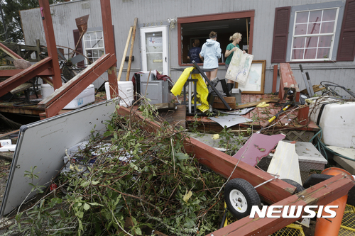 【케이티=AP/뉴시스】미국 텍사스주 케이티에서 26일(현지시간) 주민들이 허리케인 하비가 휩쓸고 지나가면서 풍비박살난 건물 주변을 살펴보고 있다. 2017.08.27