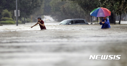 【휴스턴=AP/뉴시스】미국 텍사스주 휴스턴에서 27일(현지시간) 주민 두 사람이 허리케인 하비로 폭우가 내려 물에 잠긴 도로를 걸어가고 있다. 2017.08.28
