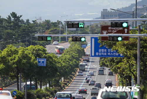 【제주=뉴시스】우장호 기자 = 제주 교통체제 개편 시행 사흘 째인 지난 2017년 8월 28일 오전 제주공항에서 신제주입구교차로(해태동산) 공항로 800m 구간까지 적용된 중앙 우선차로(파란색선 왼쪽)에 진입이 허용되지 않은 렌터카 승용차가 버스 사이사이를 달리고 있다. 2017.08.28. woo1223@newsis.com