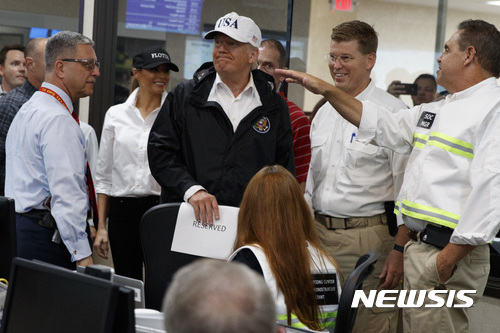 【오스틴( 미 텍사스주) = AP/뉴시스】 = 도널드 트럼프 대통령이 부인 멜라니아와 함께 29일(현지시간) 텍사스주도 오스틴의 비상재해대책본부에서 수해 현황에 대해 듣고 있다.  