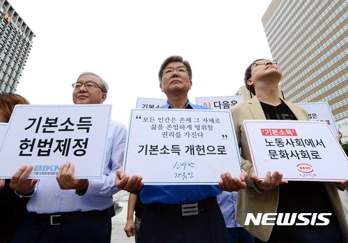 【서울=뉴시스】조성봉 기자 = 홍세화(가운데) 장발장 은행장을 비롯한 참석자들이 30일 오전 서울 종로구 광화문 이순신동상 앞에서 열린 기본소득 개헌운동 출발 기자회견에서 기본소득 개헌을 촉구하는 피켓을 들고 있다. 2017.08.30.suncho21@newsis.com