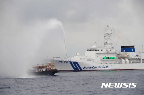 【서울=뉴시스】 일본 해산보안청 소속 선박(오른쪽)이 자국의 배타적경제수역(EEZ)내에서 불법 조업을 벌이는 북한 어선을 퇴거 시키기 위해 물대포를 쏘고 있다. (사진출처:해산보안청) 2017.09.01. 