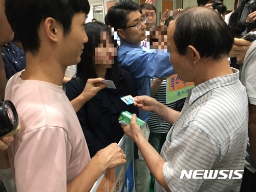 【서울=뉴시스】임재희 기자 = 5일 오후 서울 강서구 탑산초등학교에서 열린 '강서지역 특수학교 설립 교육감-주민토론회'에서 특수학교 설립에 반대하는 참석자(오른쪽 첫 번째)가 손팻말을 든 참석자가 강서구민인지 확인하기 위해 신분증을 검사하고 있다. 2017.09.05. limj@newsis.com