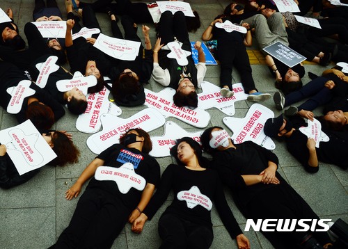 【서울=뉴시스】조성봉 기자 = 5일 오전 서울 종로구 정부서울청사 앞에서 열린 생리대 전 성분 조사와 역학조사 실시 촉구 기자회견에서 여성환경연대 회원을 비롯한 참가자들이 ‘내몸이 증거다’ 다이인(Die-in) 퍼포먼스를 하고 있다. 참가자들은 기자회견문을 통해 “정부는 시간과 비용이 들더라도 즉시 이 문제를 해결하기 위한 정확한 유해물질 전성분 조사와 잘 설계된 철저한 역학조사를 진행해야한다”고 촉구했다. 2017.09.05.suncho21@newsis.com