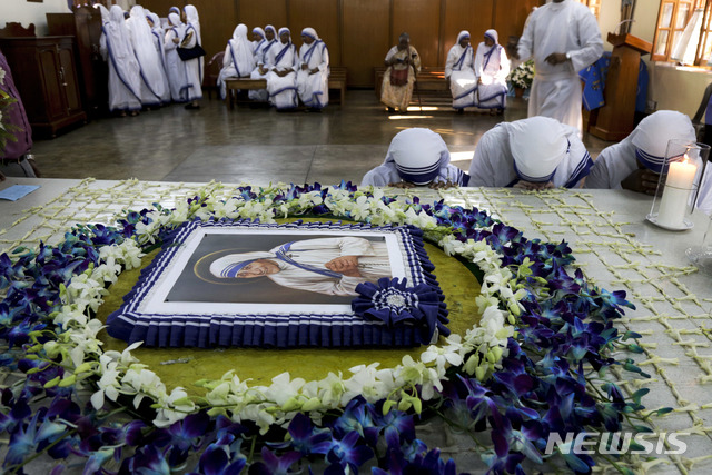 【콜카타(인도)=AP/뉴시스】인도 수녀들이 2017년 9월5일 성녀 테레사의 서거 20주기를 맞아 콜카타의 테레사 수녀 무덤에서 기도하고 있다. 이달 초 수녀 1명과 '테레사 수녀 사랑의 선교회' 직원 1명이 아기를 불법 매매하려다 체포되면서 인도 당국이 '테레사 수녀 사랑의 선교회'에 대한 조사에 착수했다. 2018.7.17